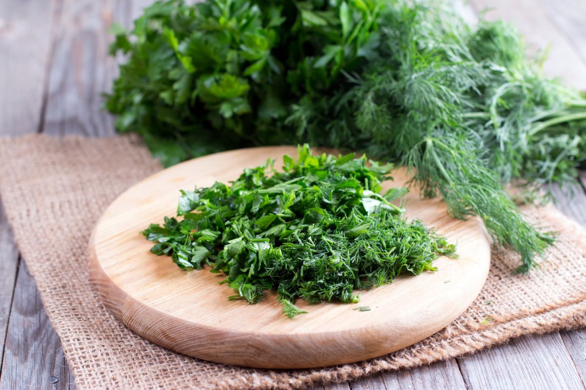 Freshly chopped parsley on a wooden chopping board on a wooden table.
