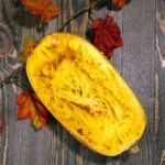 Half of spaghetti squash on a wooden table.
