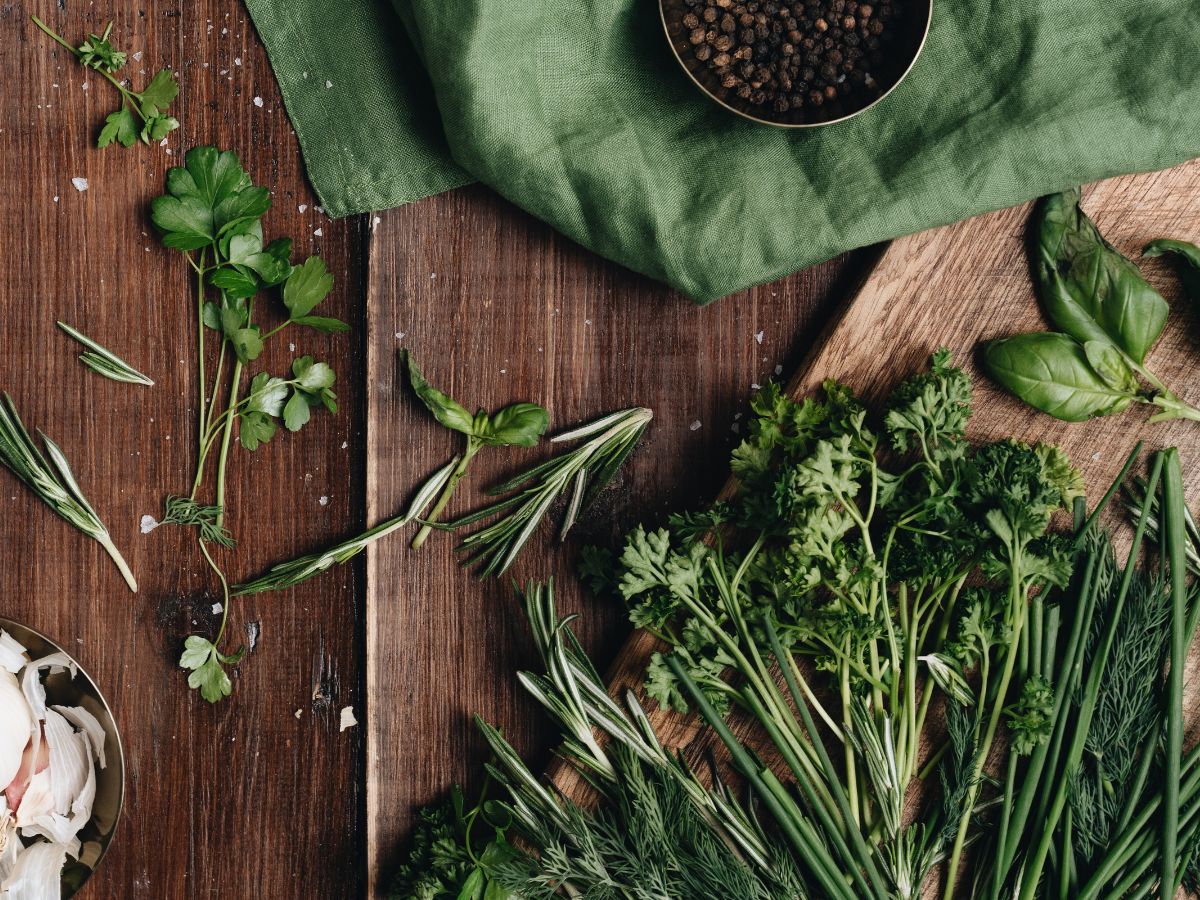 Different types of herbs on a wooden table.