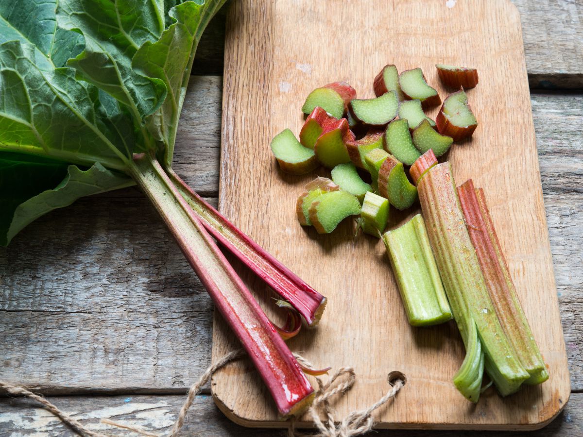 Sliced rhubarb on a wooden cutting board.