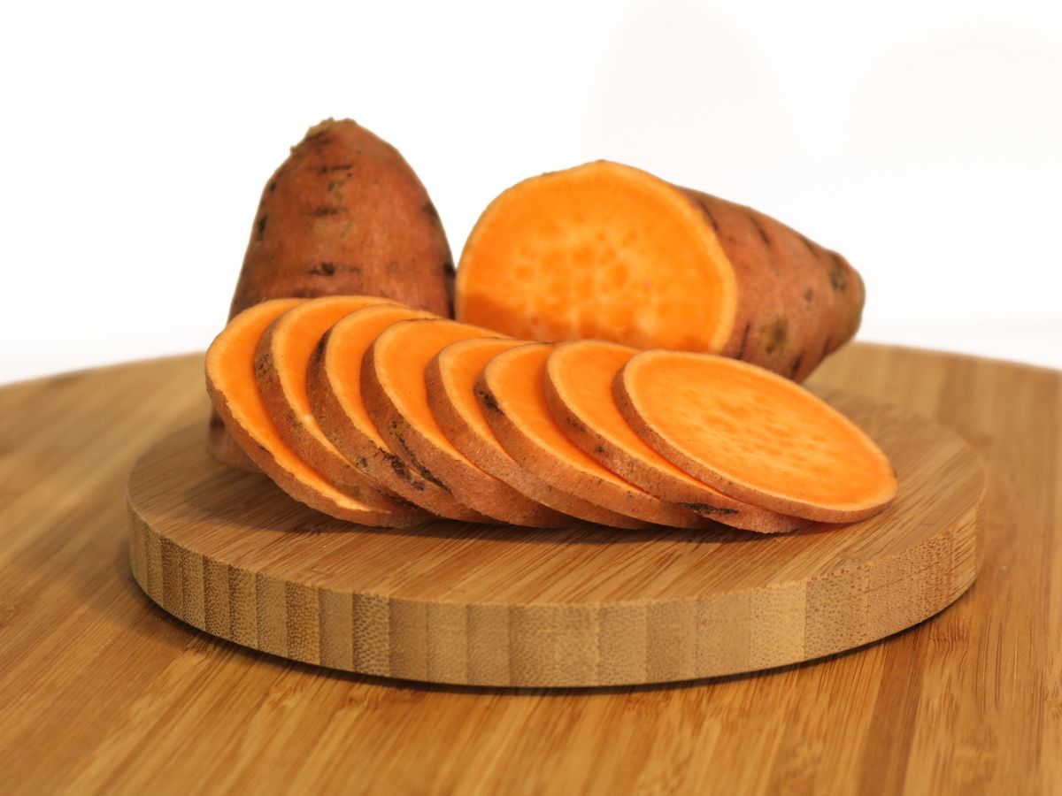 Sliced sweet potato on a wooden cutting board.