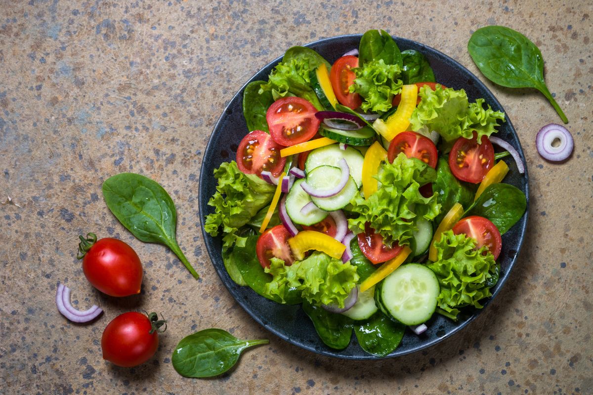 A plate is full of freshly sliced vegetables.