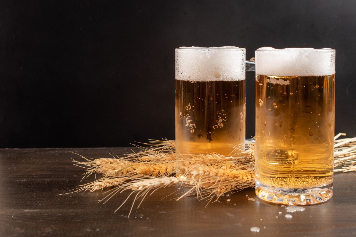 Two glasses of beer on a table.