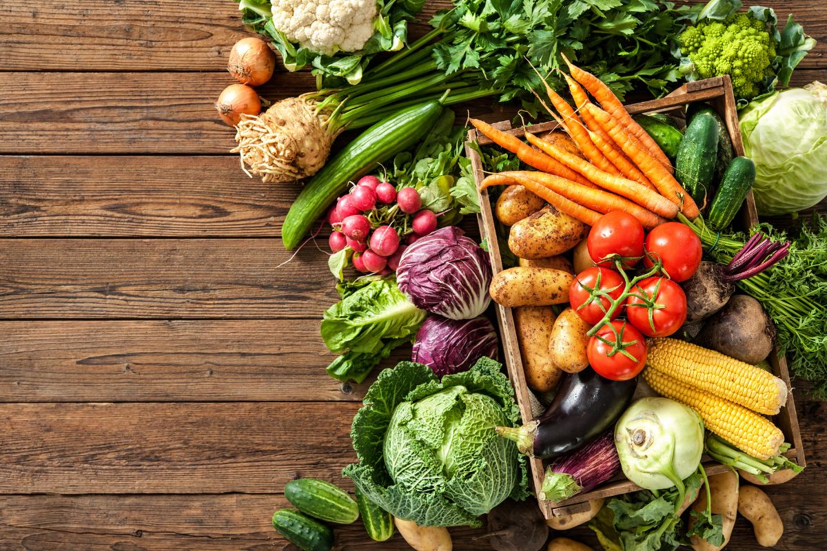 Different varieties of vegetables on a wooden table.