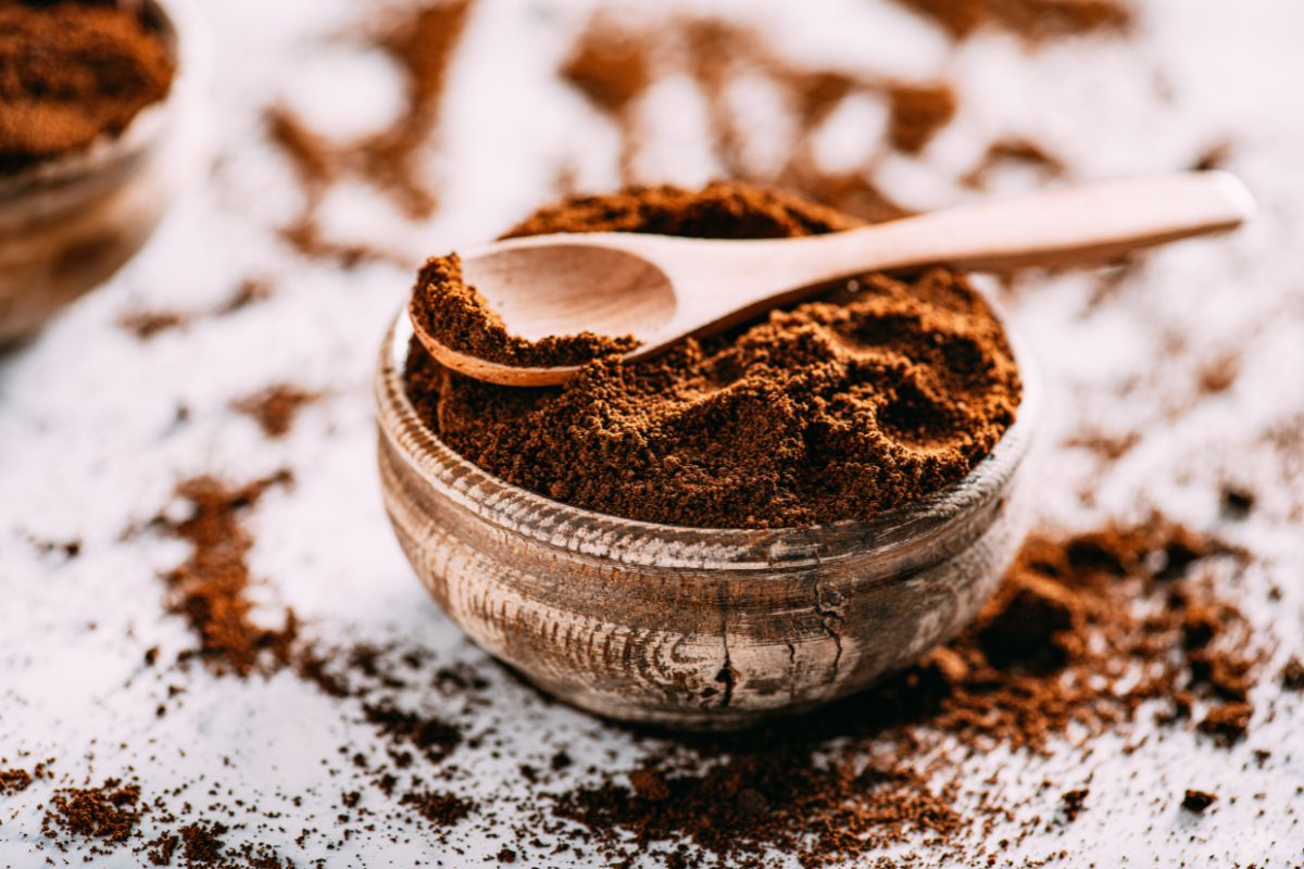 A bowl of coffee with a wooden spoon on a table.