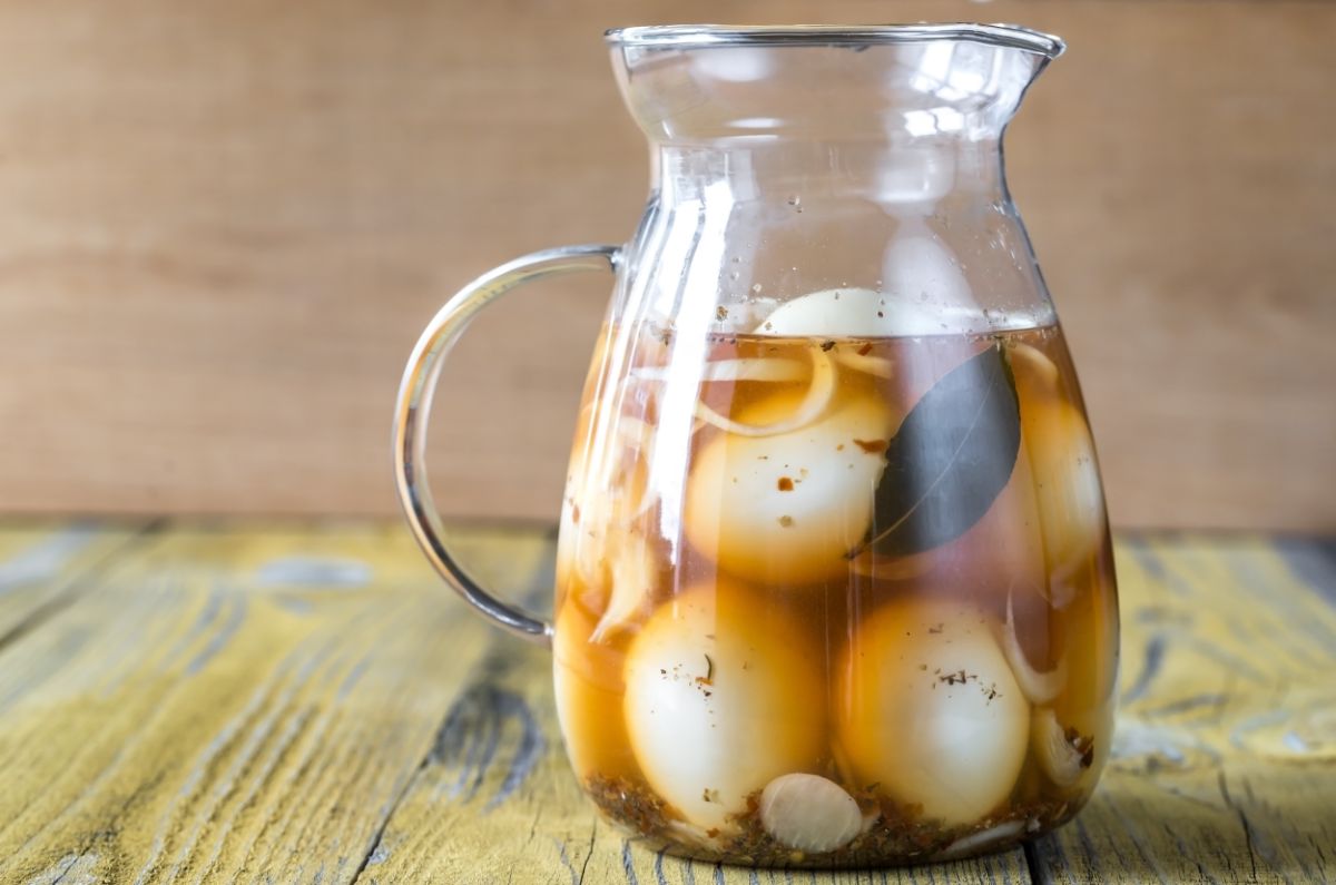 Preserved chicken eggs in a glass jar on a table.